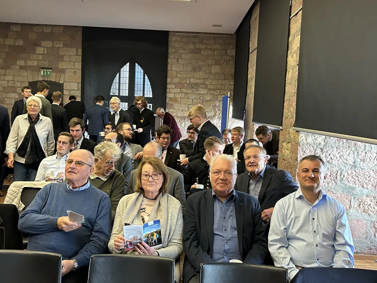 Teilnehmende des Hermann-Ehlers-Symposions 2023 im Hambacher Schloss vor Beginn der Tagung, mit Kaffee und Programmheften