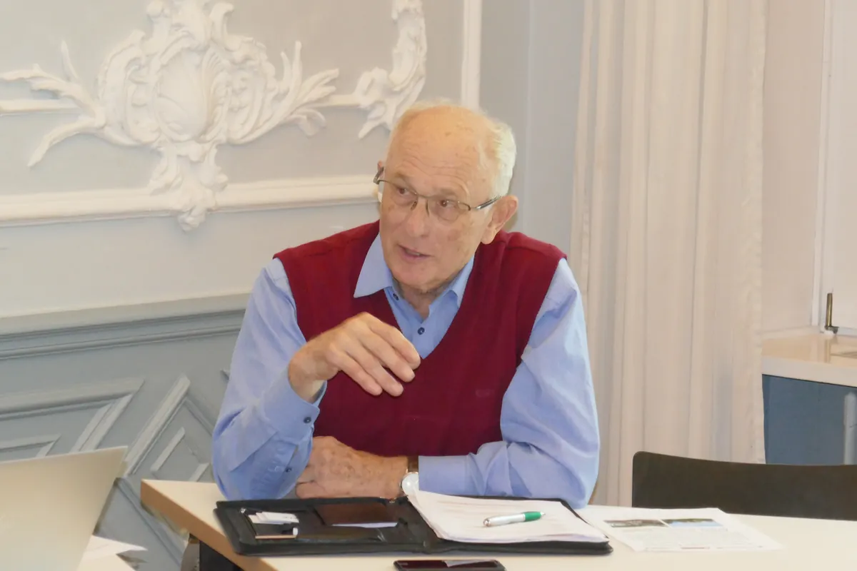 Hermann-Ehlers-Symposion 2022: Ein älterer Teilnehmer im roten Pullunder bringt sich in die Diskussion ein