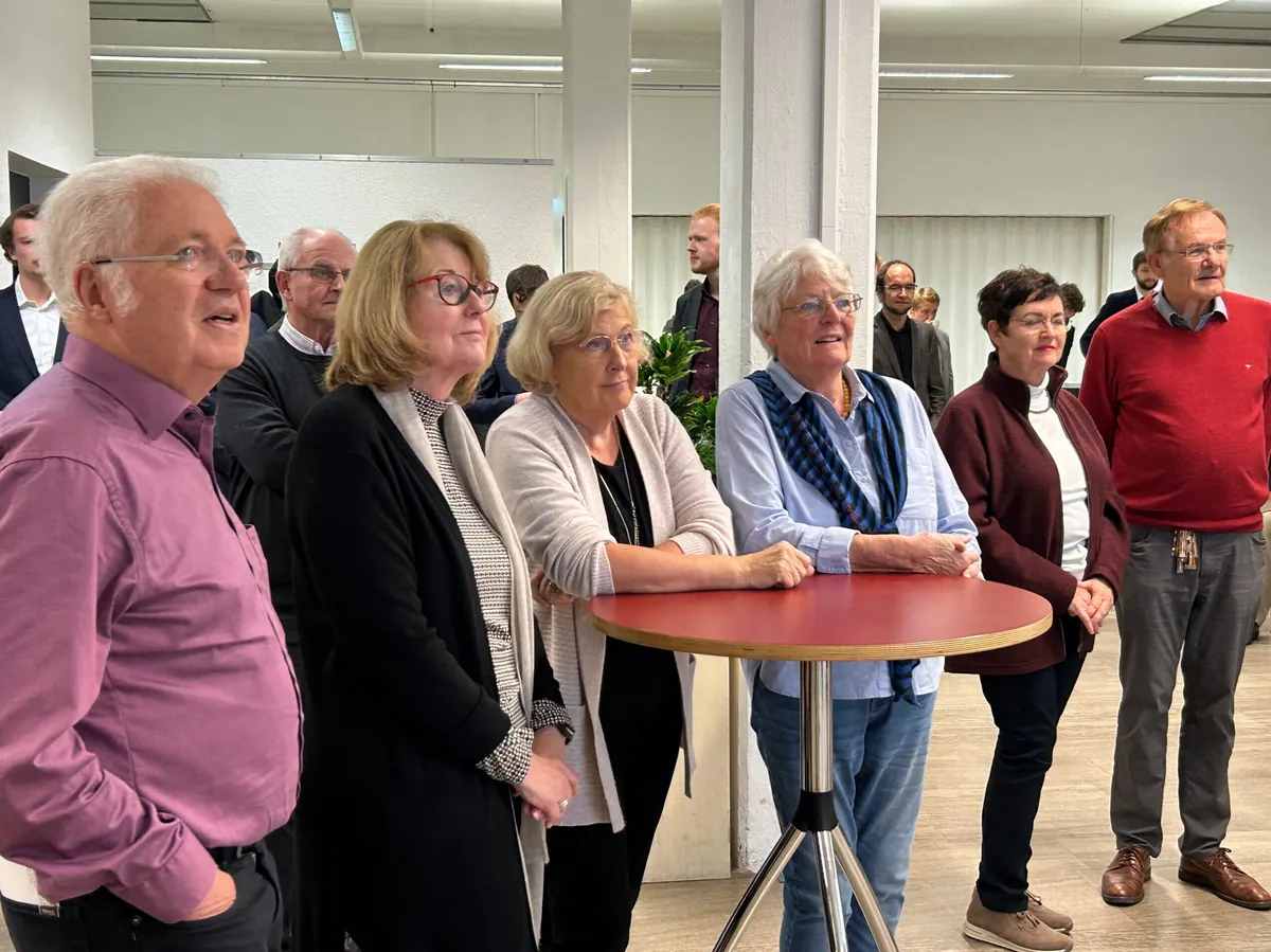 Hermann-Ehlers-Symposion 2024 in Gießen: Teilnehmende im Gespräch an einem Stehtisch in der Pause